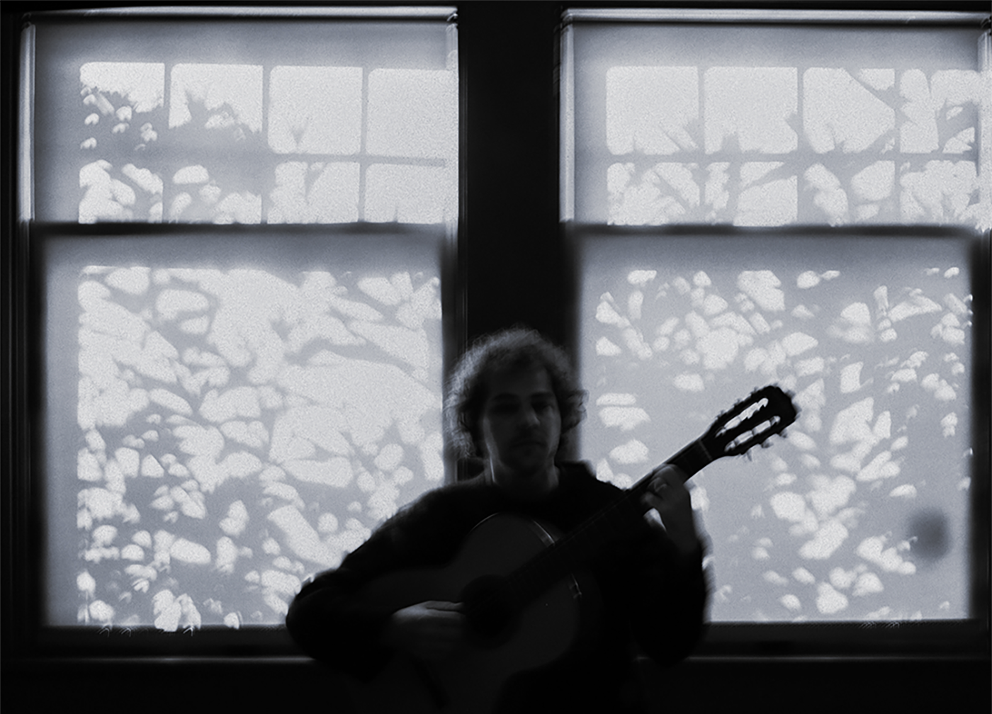 Mati Gavriel with a guitar in a dark studio